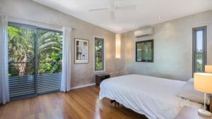 a bedroom with a bed and a large window at Moffat Retreat, Moffat Beach in Caloundra