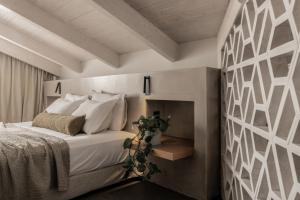 a bedroom with a bed with white pillows at Dannas Boutique Hotel & Suites in Tsilivi +55 photos