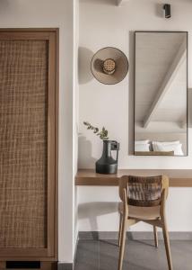 a room with a mirror and a chair and a table at Dannas Boutique Hotel & Suites in Tsilivi