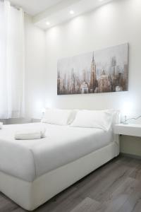 um quarto branco com uma cama branca e um quadro na parede em LA CORTE LUXURY APARTMENT em Milão