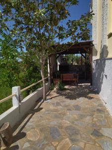 a stone walkway with a bench and a tree at AlkyonaBeach Polimeris in Platanitis Rodopis