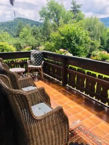 balcón con sillas y mesas de mimbre y vistas en Home Sweet Vacation Home, en Ledenitzen