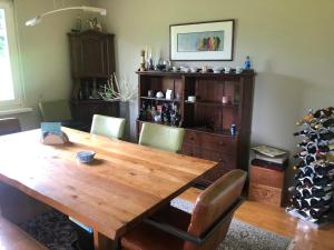 una mesa de madera en una habitación con una estantería de botellas de vino en Home Sweet Vacation Home en Ledenitzen