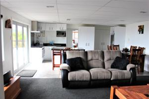 a living room with a couch and a kitchen at Serenity Views in Rotorua