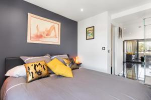 1 dormitorio con 1 cama con almohadas coloridas en Village Naturiste R4N - Cap Caline Port Nature Coursive Luxe en Cap d'Agde