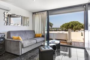 sala de estar con sofá y mesa en Village Naturiste R4N - Cap Caline Port Nature Coursive Luxe en Cap d'Agde