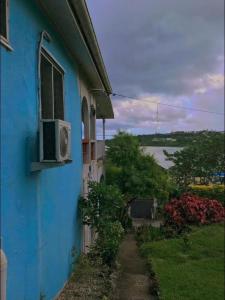 a blue building with a window and a walkway at Room With A View & Apartment Style in Port Vila