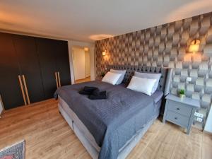 a bedroom with a large bed and a wall at Storchennest in Dresden