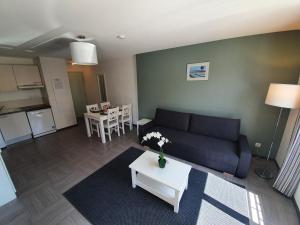 un soggiorno con un divano e un tavolo di L'Arbousier - Piscine & climatisation a Gréoux-les-Bains