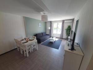 un soggiorno con un divano e un tavolo di L'Arbousier - Piscine & climatisation a Gréoux-les-Bains Altre 2 foto