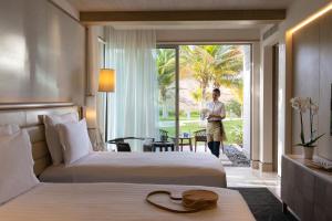a woman standing in a hotel room with two beds at Jumeirah Muscat Bay Oman in Muscat +37 photos