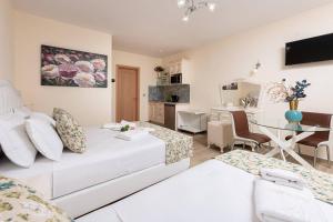 a living room with a white couch and a desk at Stratos Deluxe Apartments in Skala Potamias