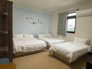 Zimmer mit 3 Betten und einem Fenster in der Unterkunft Fuzhongju Homestay in Jincheng