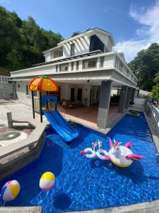 uma casa com uma piscina com brinquedos em Villa near SPICE Arena 3BR 15PAX with KTV Pool Table and Kids Swimming Pool em Bayan Lepas