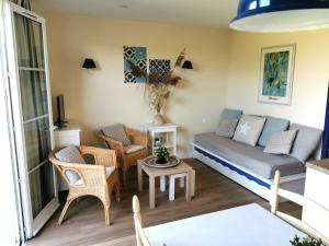 a living room with a couch and a table at Les Roseaux - Piscine chauffee in Talmont-Saint-Hilaire