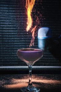 a wine glass with a purple drink in front of a fire at Plaza Hotel & Casino in Las Vegas