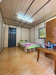 a room with a bed and a table in it at CabinStay Cikgu Sungai Batu Besi in Sungai Petani