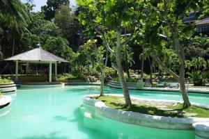 a swimming pool with trees and a gazebo at Elysia Nongsa 29 Batam Beachfront in Nongsa
