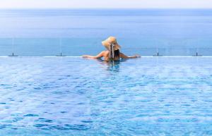a person in a hat sitting in the water at Grabel Hotel Jeju in Jeju