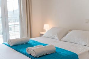 two towels on a bed in a bedroom with a window at Villa Kallithea in Parga