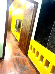 Zimmer mit gelber Tür und TV in der Unterkunft DRONA HILLS RESORTS in Kanatal