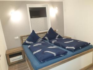 a bedroom with two blue pillows on a bed at Ferienwohnung Wiehelund - Großenwiehe in Lindewitt