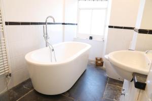 a bathroom with a large tub and a sink at Stowaway, Port Isaac Bay Holidays in Port Isaac