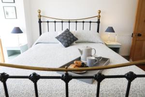 a bed with a tray with a tea set on it at Stowaway, Port Isaac Bay Holidays in Port Isaac