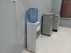 un refrigeratore d'acqua con sopra un secchio blu di Alias Residence - Homestay Kubang Kerian a Kota Bharu