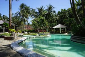 a swimming pool in a resort with palm trees at Elysia Nongsa 24 Batam Luxury Villa in Nongsa