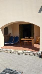 patio z krzesłami, stołem i ekranem w obiekcie Marilena Apartment Olive Tree w mieście Gavalochori