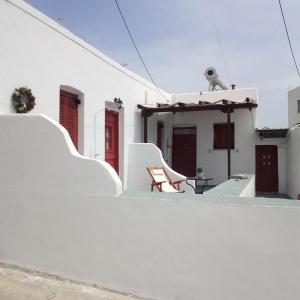 un edificio bianco con una sedia sul lato di Venduri House a Péran Triovasálos