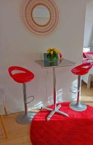 dos sillas rojas y una mesa con una alfombra roja en Nuit Romantique avec Jacuzzi à 15 min de Toulouse, en Blagnac