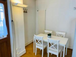 a white dining room table with four white chairs at Apartment Marktplatz 2 in Basel