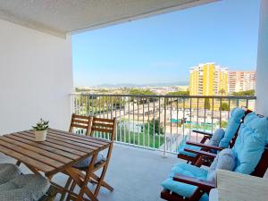 カネット・デ・ベレンゲルにあるGlobal Properties, Apartamento nuevo en la playa de Canet d'en Berenguerのリビングルーム(テーブル、椅子付)、バルコニーが備わります。