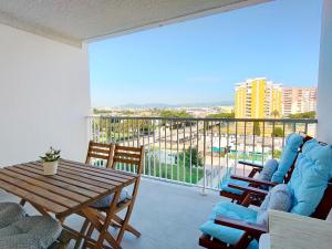 ein Wohnzimmer mit Tisch und Stühlen und einem Balkon in der Unterkunft Global Properties, Apartamento nuevo en la playa de Canet d'en Berenguer in Canet d'en Berenguer