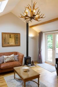 a living room with a couch and a wood stove at Luxury Barn near Stamford in Wansford