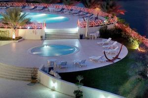 迪拜码头酒店公寓的一个带桌椅和灯光的大型游泳池