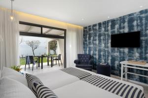 a bedroom with a bed and a tv and a table at Ein Gev Holiday Resort in Ein Gev