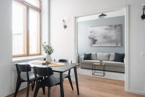 een woonkamer met een tafel en stoelen en een bank bij 2ndhomes Tampere "Klingendahl" Apartment - Historical Apt with Sauna & Free Parking in Tampere