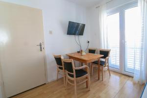 a dining room with a wooden table and chairs at Apartment Bili-sea view apartment in the center in Makarska