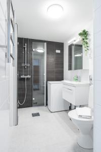 a bathroom with a shower and a toilet and a sink at 2ndhomes Tampere "Otavala" Apartment - Just Renovated - Hosts 8 in Tampere