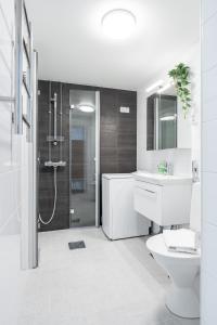 a bathroom with a shower and a toilet and a sink at Newly Renovated 1BR Home that Hosts up to 8 Guests - Hosted by 2ndhomes in Tampere