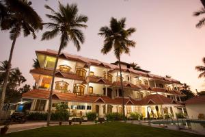 ein großes Gebäude mit Palmen davor in der Unterkunft The Sanctum Spring Beach Resort in Varkala