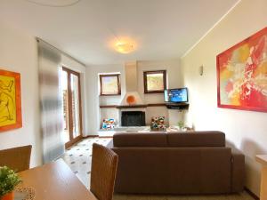 - un salon avec un canapé et une télévision dans l'établissement Casa Cinzia, à Gravedona