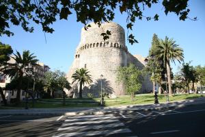 a building with a tower with palm trees and a street at Bed and Breakfast Dolce Noemi in Reggio di Calabria