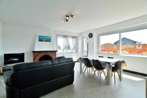 sala de estar con sofá y mesa con sillas en Maison spacieuse à saint coulomb, en Saint-Coulomb