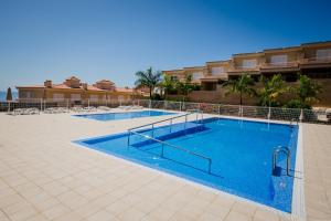 a large swimming pool in front of a building at Residencial Playa de La Arena in Puerto de Santiago