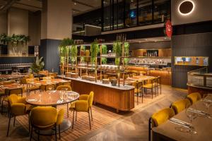 a restaurant with tables and chairs and a bar at voco Auckland City Centre, an IHG Hotel in Auckland