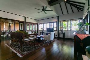a living room with a couch and a ceiling fan at ELYSIA NONGSA 91 BATAM LUXURY VILLA in Nongsa